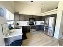 Modern kitchen with stainless steel appliances, dark cabinets, and quartz countertops at 8673 W Palm Ln, Phoenix, AZ 85037