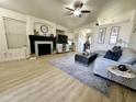 Bright, open living room featuring a fireplace, wood floors, and neutral decor at 8673 W Palm Ln, Phoenix, AZ 85037