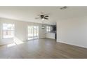 Open concept living room with vinyl flooring, ceiling fan, and views of the kitchen and backyard at 12813 W Paradise Dr, El Mirage, AZ 85335