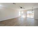 Spacious living room with vinyl flooring, ceiling fan, recessed lighting, and sliding glass doors to the backyard at 12813 W Paradise Dr, El Mirage, AZ 85335