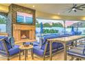 Outdoor living space featuring a stone fireplace, seating, outdoor television, and resort-style pool at 13074 E Saddlehorn Trl, Scottsdale, AZ 85259