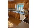 Kitchen featuring wood cabinets, laminate floors, and stainless steel sink under window at 6223 N 12Th St # 1, Phoenix, AZ 85014
