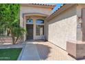 Home featuring covered front door and walkway with brick accents and desert landscaping at 8354 W Marlette Ave, Glendale, AZ 85305