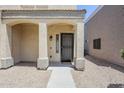 Charming covered front porch with decorative columns offering a welcoming entry to the home at 15205 N Honcho Ct, El Mirage, AZ 85335