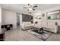 Living room with modern finishes including gray wood floors, white couch, and barn door at 1531 W Campo Bello Dr, Phoenix, AZ 85023