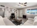 Living room featuring wood laminate flooring, a ceiling fan, neutral paint, and ample natural light at 1531 W Campo Bello Dr, Phoenix, AZ 85023