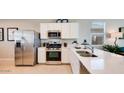 Modern kitchen with stainless steel appliances, white cabinets and a large countertop at 16762 W Alameda Rd, Surprise, AZ 85387