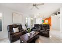Bright living room featuring neutral walls, tile flooring, plantation shutters, and comfortable leather seating at 3550 E Edna Ave, Phoenix, AZ 85032