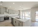 Modern kitchen with a large island, stainless steel appliances, gray cabinets, and quartz countertops at 44538 W Canyon Creek Dr, Maricopa, AZ 85139