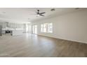 Spacious living room featuring light floors, a ceiling fan, and sliding doors to the backyard at 44538 W Canyon Creek Dr, Maricopa, AZ 85139