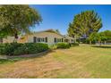 Landscaped front lawn with mature shade trees surrounding the home at 5613 E Calle Del Paisano --, Phoenix, AZ 85018