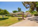 Well-manicured front lawn with an expansive circular driveway and two car garage at 5613 E Calle Del Paisano --, Phoenix, AZ 85018