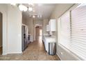 Bright kitchen with stainless steel appliances, white cabinets, and tile flooring at 6610 E University Dr # 163, Mesa, AZ 85205