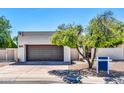 Charming home exterior with a two-car garage, desert landscaping, and a well-maintained lawn at 6615 E Phelps Rd, Scottsdale, AZ 85254