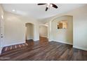 Spacious living room featuring wood floors, arched openings, and a ceiling fan for added comfort at 21017 W Edith Way, Buckeye, AZ 85396