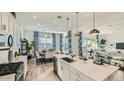 Bright open concept kitchen with an island and stainless appliances, seamlessly flowing into dining and living areas at 2955 E Lucky Horseshoe Ln, San Tan Valley, AZ 85140