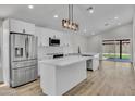 Modern kitchen featuring white cabinetry, stainless steel appliances, and an island with a quartz countertop at 3926 E Coconino St, Phoenix, AZ 85044