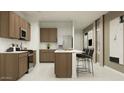 Well-designed kitchen with stainless steel appliances, center island, and stylish pendant lighting at 9552 W Verde Ln, Phoenix, AZ 85037