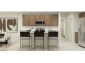 Modern kitchen features sleek cabinets, stainless steel appliances, and a convenient breakfast bar at 9552 W Verde Ln, Phoenix, AZ 85037