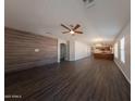 Spacious living room with dark wood-look floors, a ceiling fan, and ample natural light at 1381 E Prickly Pear Dr, Casa Grande, AZ 85122