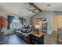 Comfortable living room featuring a vaulted ceiling, stylish furniture, and an abundance of natural light from the window at 6433 E University Dr, Mesa, AZ 85205