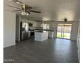 Bright, open kitchen features white cabinets, stainless appliances, and gray tile floors at 1818 N 63Rd Ave, Phoenix, AZ 85035