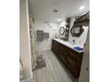 Bathroom with a modern vanity, double sinks, decorative mirrors, and a shower with a patterned curtain at 4729 W Eva St, Glendale, AZ 85302