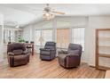 Bright living room with high ceilings, three recliners, laminate floors, and natural light from multiple windows at 5735 E Mcdowell Rd # 436, Mesa, AZ 85215