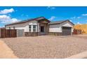 Cozy single-story home with stone accents, a brick driveway, and a two-car garage at 8226 W Swansea Dr, Arizona City, AZ 85123