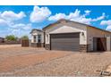 Single-story home showcasing a modern two-car garage and brick driveway, blending style and convenience at 8226 W Swansea Dr, Arizona City, AZ 85123