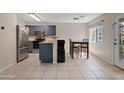Open kitchen with stainless steel appliances, blue cabinets, and adjacent dining area at 125 S 56Th St # 27, Mesa, AZ 85206