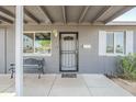 Close-up of the entrance with a bench, security door, and white trimmed windows at 6147 W Rose Cir, Phoenix, AZ 85033