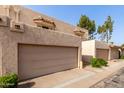 Beige townhome featuring a two-car garage, stucco walls, and classic tile roofing at 8540 N Central Ave # 6, Phoenix, AZ 85020