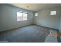 Spacious bedroom with neutral carpet and large windows offering plenty of natural light at 10217 W Fairmount Ave, Avondale, AZ 85392