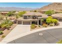 Stunning elevated view of desert home featuring a three-car garage and vibrant landscaping and nearby mountain views at 16224 S Reserve Dr, Phoenix, AZ 85045