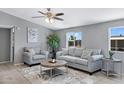 Comfortable living room featuring gray walls, stylish furniture, a decorative ceiling fan, and natural light from the window at 320 E Mckellips Rd # 34, Mesa, AZ 85201