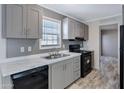 Well-lit kitchen featuring black appliances, a stainless steel sink, and modern light gray cabinetry at 320 E Mckellips Rd # 4, Mesa, AZ 85201