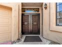 Close up of charming double door entry with security screen and desert landscaping at 7955 E Chaparral Rd # 17, Scottsdale, AZ 85250