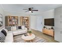 Cozy living room featuring hardwood floors, sectional sofa, built-in bookshelves, and accent rug at 320 E Mckellips Rd # 186, Mesa, AZ 85201