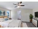 The light-filled bedroom showcases a ceiling fan and ensuite bathroom with a neutral palette and comfortable furnishings at 320 E Mckellips Rd # 204, Mesa, AZ 85201