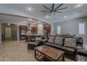 Spacious living room featuring an open floorplan, tile floors and dark leather furniture at 4135 E Grand Canyon Dr, Chandler, AZ 85249