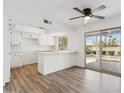 Eat-in kitchen boasting a ceiling fan, quartz counters, white cabinets, a breakfast bar and sliding glass doors at 4829 E Apache Cir, Phoenix, AZ 85044