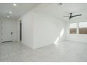 Bright, open living area with neutral tile, ceiling fan, and natural light at 2732 N 217Th Ave, Buckeye, AZ 85396
