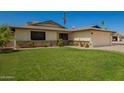 Charming single-Gathering home featuring a two-car garage, manicured lawn, and vibrant rose bushes at 3828 W Port Au Prince Ln, Phoenix, AZ 85053