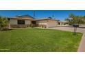 Well-maintained single-Gathering home with a lush green lawn, rose bushes, and two-car garage at 3828 W Port Au Prince Ln, Phoenix, AZ 85053