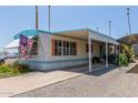 Inviting manufactured home with a spacious carport, covered patio, and low-maintenance gravel landscaping at 4065 E University Dr # 76, Mesa, AZ 85205