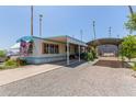 Inviting manufactured home with a spacious carport, covered patio, and low-maintenance gravel landscaping at 4065 E University Dr # 76, Mesa, AZ 85205