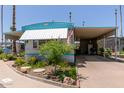 Charming manufactured home featuring a carport, manicured landscaping, and a welcoming curb appeal at 4065 E University Dr # 76, Mesa, AZ 85205