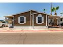 Charming single-story home featuring brown siding, white trim, and a well-maintained front yard at 625 W Mckellips Rd # 411, Mesa, AZ 85201