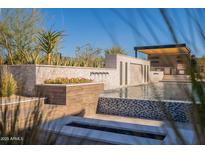 Stunning backyard with a resort-style pool, water feature, and outdoor kitchen at 8366 E Old Paint Trl, Scottsdale, AZ 85266